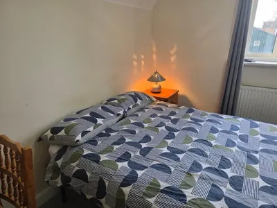 a bedroom with a bed and a lamp on a table at Free Parking WiFi Fresh linens x4 in Hythe
