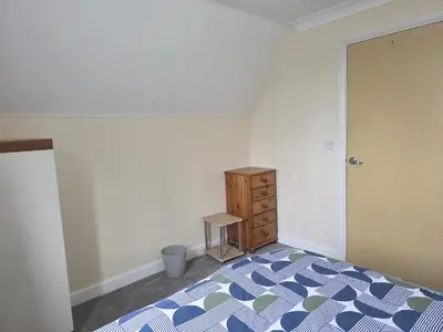 a bedroom with a bed and a wooden dresser at Free Parking WiFi Fresh linens x4 in Hythe