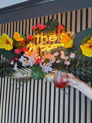 a person holding a fruit in front of a sign with flowers at Stylish Garden pod lodges in Milton
