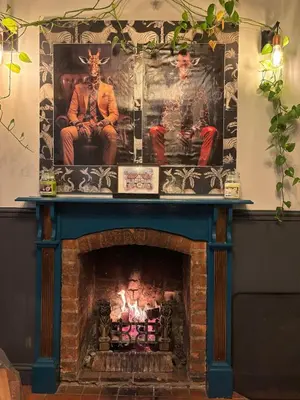 a fireplace with two men sitting on top of it at Stylish Garden pod lodges in Milton