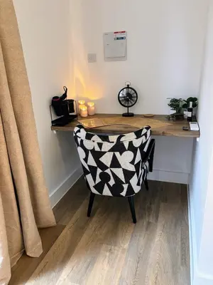 a desk with a chair in a room with a table at Stylish Garden pod lodges in Milton