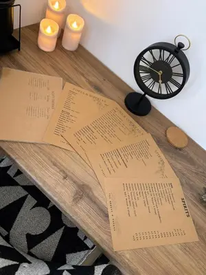 a table with two pieces of paper and candles at Stylish Garden pod lodges in Milton