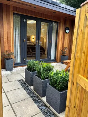 a group of potted plants in front of a house at Stylish Garden pod lodges in Milton