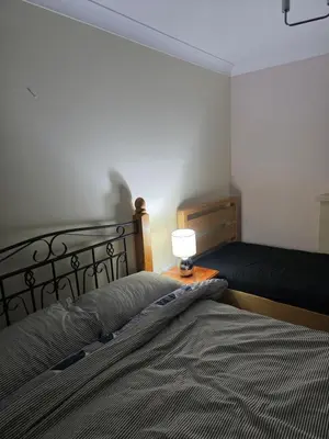 a bedroom with a bed with a lamp on a table at Cosy in Colchester x5 in Hythe