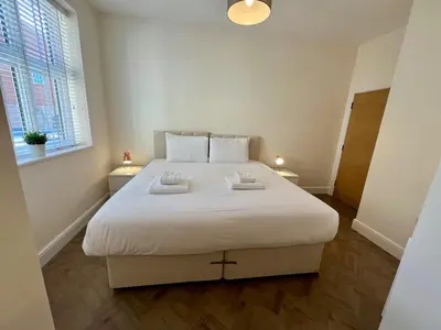 a large white bed in a room with a window at 4 The Royal Serviced Apartments, Harwich - Garden- Parking-Fast WiFi in Parkeston