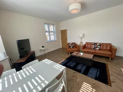 a living room with a couch and a table at 4 The Royal Serviced Apartments, Harwich - Garden- Parking-Fast WiFi in Parkeston