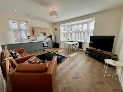 a living room with a couch and a tv at 4 The Royal Serviced Apartments, Harwich - Garden- Parking-Fast WiFi in Parkeston