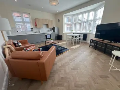 a living room with a couch and a tv at 4 The Royal Serviced Apartments, Harwich - Garden- Parking-Fast WiFi in Parkeston