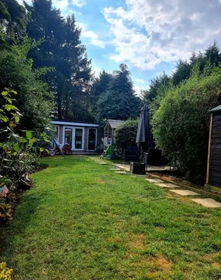 a yard with a house and an umbrella at 3-bedroom family home with large garden and free parking in Loughton