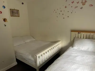 two twin beds in a small room with at 3-bedroom family home with large garden and free parking in Loughton