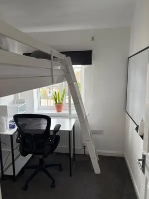 a room with a desk and a loft bed and a chair at 3-bedroom family home with large garden and free parking in Loughton