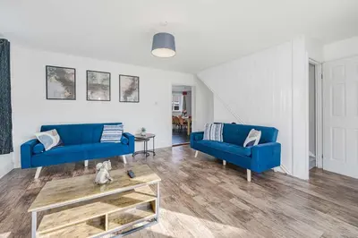 a living room with two blue couches and a coffee table at Modern Comfort 4BR House in Colchester