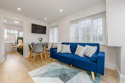 a living room with a blue couch and a table at Cosy and Peaceful flat in Benfleet close to station in South Benfleet