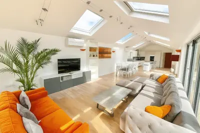 a living room with a couch and a table at Countryside Retreat - Indoor Pool, Sauna, Hot Tub in Fowlmere