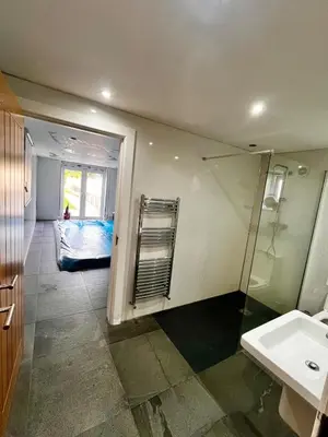 a bathroom with a shower and a sink and a mirror at Countryside Retreat - Indoor Pool, Sauna, Hot Tub in Fowlmere