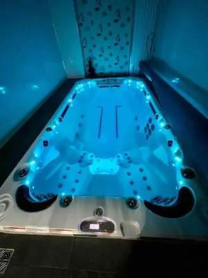 a blue bath tub with lights in a bathroom at Countryside Retreat - Indoor Pool, Sauna, Hot Tub in Fowlmere