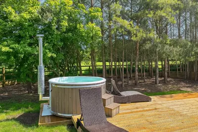 a hot tub sitting on top of a wooden deck at Countryside Retreat - Indoor Pool, Sauna, Hot Tub in Fowlmere