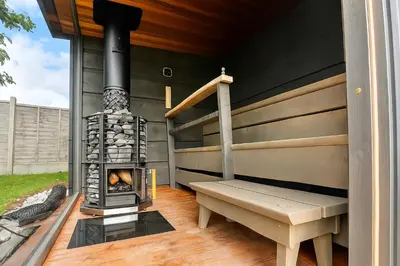 a patio with a woodburning stove and a bench at Countryside Retreat - Indoor Pool, Sauna, Hot Tub in Fowlmere