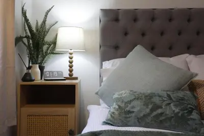 a bedroom with a bed with a lamp and a plant at Modern 2Bedroom Apartment Free Private Parking Woodbridge Central in Woodbridge