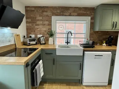 a kitchen with green cabinets and a sink and a window at Modern 2Bedroom Apartment Free Private Parking Woodbridge Central in Woodbridge