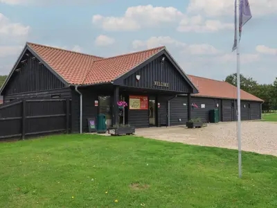 a black barn with a flag in front of it at Carabelle Cow Shed 7 in Woodbridge