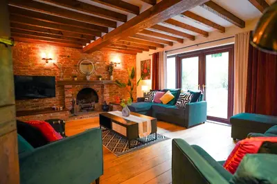 a living room with a couch and a fireplace at Bright & Spacious 5-Bedroom Stay near Cambridge in Hardwick