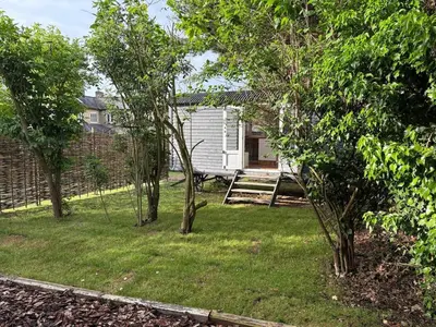 a backyard with trees and a house at Shepherds hut in Holywell Cambridgeshire in Holywell