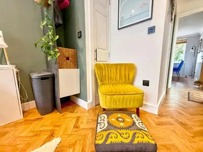 a living room with a yellow chair and a rug at Charming 4 bedroom home in Felsted in Felsted