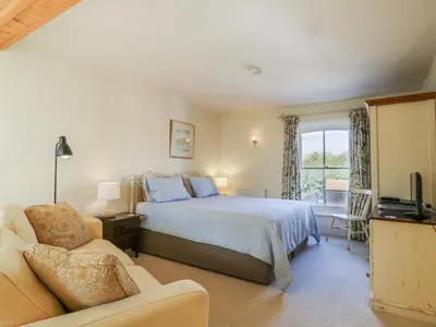 a bedroom with a bed and a couch and a television at Over Village Studio in Cambridge