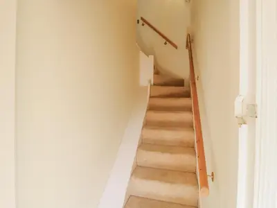 a staircase in a home with white walls at Over Village Studio in Cambridge