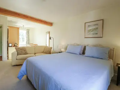 a bedroom with a large white bed and a couch at Over Village Studio in Cambridge