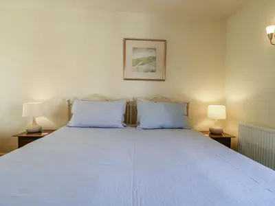 a bedroom with a large bed with two blue pillows at Over Village Studio in Cambridge