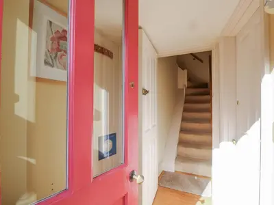 a red door in a hallway with a staircase at Over Village Studio in Cambridge