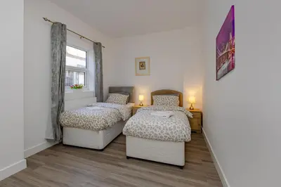 a bedroom with two beds and a window at Blue Horizon Seaside Apart in Clacton-on-Sea