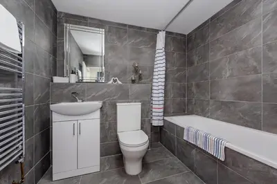 a bathroom with a toilet and a sink and a tub at Blue Horizon Seaside Apart in Clacton-on-Sea
