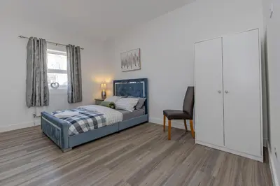 a bedroom with a bed and a desk and a chair at Blue Horizon Seaside Apart in Clacton-on-Sea
