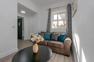 a living room with a couch and a vase with flowers on a table at Triple B Aparto in Clacton-on-Sea