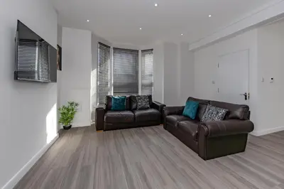 a living room with two leather couches and a television at Triple B Aparto in Clacton-on-Sea