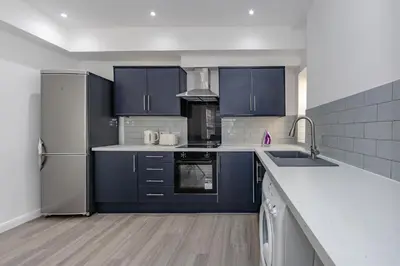 a kitchen with blue cabinets and stainless steel appliances at Triple B Aparto in Clacton-on-Sea