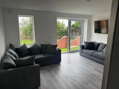 a living room with two couches and a large window at Rural Retreats 9 and 10 in Southminster
