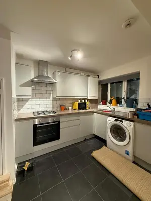 a kitchen with a washing machine in the middle at 3 Bed Home, Sleeps 7 with Garden in Basildon in Basildon