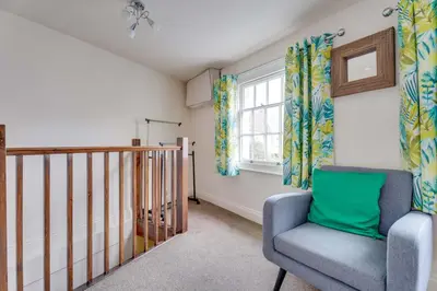 a living room with a chair and a window at The Old Shoe Shop, 5 Well Lane in Clare