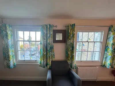 a living room with two windows and a couch at The Old Shoe Shop, 5 Well Lane in Clare