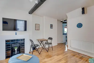 a living room with a table and chairs and a fireplace at The Old Shoe Shop, 5 Well Lane in Clare