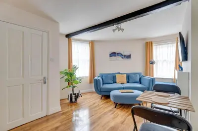 a living room with a blue couch and a table at The Old Shoe Shop, 5 Well Lane in Clare