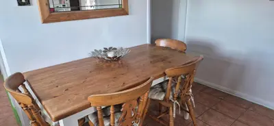 a wooden dining room table with chairs and a mirror at Cambridgeshire Cosy Cottage in Cottenham