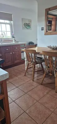a kitchen with a table and chairs in a room at Cambridgeshire Cosy Cottage in Cottenham