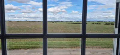 a view of a field from a window at Cambridgeshire Cosy Cottage in Cottenham