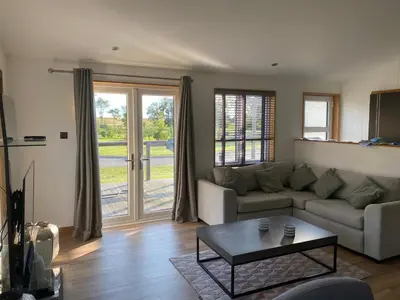 a living room with a couch and a coffee table at Contemporary 3 bed luxury Spa lodge with hot tub in Bury Saint Edmunds