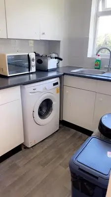 a kitchen with a washing machine and a microwave at Home in Colchester in Colchester